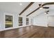 Living room featuring hardwood floors, natural light from three windows, and access to another room at 4178 Castle Pines Ct, Tucker, GA 30084