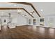Bright living room with vaulted ceilings, wood beams, hardwood floors, modern lighting, and a view of the kitchen at 4178 Castle Pines Ct, Tucker, GA 30084