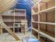 Unfinished attic space with wooden beams, rafters and built-in wooden storage shelves at 1587 Red Fox Sw Run, Lilburn, GA 30047