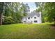 Large backyard with grass, trees, and patio at 1587 Red Fox Sw Run, Lilburn, GA 30047