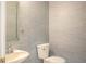 Stylish powder room featuring a sink and toilet, complemented by blue textured wallpaper at 1587 Red Fox Sw Run, Lilburn, GA 30047