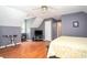 Bright bedroom featuring hardwood floors, two-tone paint, ceiling fan, and entertainment center at 1587 Red Fox Sw Run, Lilburn, GA 30047