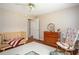 Bright, neutral Bedroom featuring a rocking chair and a wooden crib at 1587 Red Fox Sw Run, Lilburn, GA 30047