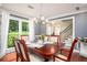 Formal dining room with hardwood floors, large window, and stylish chandelier at 1587 Red Fox Sw Run, Lilburn, GA 30047