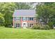 Charming two-story brick home featuring blue shutters, a manicured lawn, and mature landscaping at 1587 Red Fox Sw Run, Lilburn, GA 30047