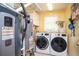 Efficient laundry room with washer, dryer, and water heater, enhanced by a bright yellow wall paint at 1587 Red Fox Sw Run, Lilburn, GA 30047
