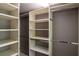 Well-organized walk-in closet featuring custom shelving and ample storage space at 1587 Red Fox Sw Run, Lilburn, GA 30047