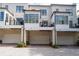 Rear view of townhomes with patios, balconies, and garages on a brick driveway at 18 Peachtree Ne Ave # 5, Atlanta, GA 30305
