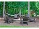 Inviting backyard space with a fire pit, hammock, and ample seating amidst mature trees at 2845 Aquitania Ln, Cumming, GA 30040