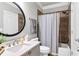 Cozy bathroom features a shower-tub combo, a toilet, and a modern sink and vanity with a dark framed mirror at 2845 Aquitania Ln, Cumming, GA 30040