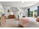 Bright bedroom featuring a dresser, a desk with built-in shelving, and large windows with backyard views at 2845 Aquitania Ln, Cumming, GA 30040