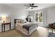 Cozy bedroom with a ceiling fan, window, neutral colors, and a stylish bedside table with decor at 2845 Aquitania Ln, Cumming, GA 30040