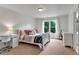 Bright bedroom featuring a large window with natural light, white trim, and a stylish desk and chair set at 2845 Aquitania Ln, Cumming, GA 30040