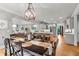 Dining room with hardwood floors, modern chandelier, and views to living area and kitchen at 2845 Aquitania Ln, Cumming, GA 30040