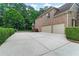 Long driveway leading to a two-car garage, complemented by manicured hedges and lush greenery at 2845 Aquitania Ln, Cumming, GA 30040