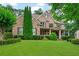 Charming two-story brick home with a well-manicured lawn, mature trees, and inviting front porch at 2845 Aquitania Ln, Cumming, GA 30040