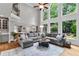 Open-concept living room with large windows, a stone fireplace, and access to the kitchen at 2845 Aquitania Ln, Cumming, GA 30040