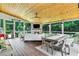 Inviting screened-in patio with a wood ceiling, stone fireplace, and comfortable seating area for outdoor living at 2845 Aquitania Ln, Cumming, GA 30040