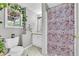 Small bathroom features a shower, toilet, vanity with sink and decorative plants at 684 Doe Lane Ln, Loganville, GA 30052