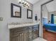 Bathroom with dual vanity granite sinks and dark wood cabinets with access to Primary bedroom at 684 Doe Lane Ln, Loganville, GA 30052