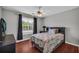Serene bedroom featuring hardwood floors, a comfortable bed, and ample natural light from the window at 684 Doe Lane Ln, Loganville, GA 30052