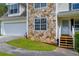 Two-story home featuring stone accents, a two-car garage, and a charming front porch with steps at 684 Doe Lane Ln, Loganville, GA 30052
