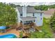 Aerial view of backyard featuring deck, patio, above-ground pool, and lush greenery at 684 Doe Lane Ln, Loganville, GA 30052