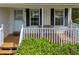 Inviting front porch featuring a wooden deck, decorative railing, and charming accents with black shutters at 684 Doe Lane Ln, Loganville, GA 30052