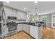 Bright kitchen featuring white cabinets, stainless steel appliances, and eat-in breakfast bar at 684 Doe Lane Ln, Loganville, GA 30052
