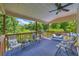 Relaxing covered patio with comfortable seating, ceiling fan, and wooded views at 684 Doe Lane Ln, Loganville, GA 30052