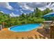 Relaxing backyard showcasing an above-ground pool with wooden deck and seating area, surrounded by lush greenery at 684 Doe Lane Ln, Loganville, GA 30052