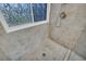 Tiled shower stall with a window and a brushed nickel showerhead and fixtures at 684 Doe Lane Ln, Loganville, GA 30052