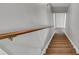 Carpeted staircase with a wooden handrail in a neutral color palette at 684 Doe Lane Ln, Loganville, GA 30052