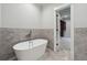 Bright bathroom featuring a standalone tub and a glimpse into a well-organized walk-in closet at 10745 Shallowford Rd, Roswell, GA 30075
