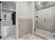 Modern bathroom featuring a glass-enclosed shower with gray stone tile and decorative tile flooring at 10745 Shallowford Rd, Roswell, GA 30075
