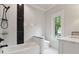 Modern bathroom with sleek black and white marble tile, bathtub, and shower at 10745 Shallowford Rd, Roswell, GA 30075
