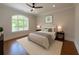 Bright bedroom with a view of the outdoors, hardwood floors, and neutral decor at 10745 Shallowford Rd, Roswell, GA 30075
