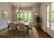 Bright dining room with hardwood floors, a modern chandelier, and a door leading to an outdoor area at 10745 Shallowford Rd, Roswell, GA 30075