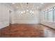 This dining room boasts wainscoting, hardwood floors, and elegant chandelier at 10745 Shallowford Rd, Roswell, GA 30075