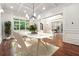 Elegant dining room with modern chandelier and a large window overlooking the yard at 10745 Shallowford Rd, Roswell, GA 30075