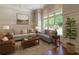 Bright living room featuring neutral furniture, wainscoting, hardwood floors, and large windows overlooking the yard at 10745 Shallowford Rd, Roswell, GA 30075