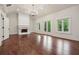 Bright, open living room with fireplace, chandelier, wood floors, and French doors at 10745 Shallowford Rd, Roswell, GA 30075