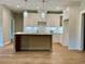 Kitchen with island, recessed lighting, white cabinets, stainless appliances, and hardwood floors at 1273 Jersey Social Circle Rd, Covington, GA 30014