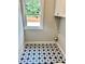 Laundry room with patterned tile flooring and a window, providing functionality and natural light at 1273 Jersey Social Circle Rd, Covington, GA 30014