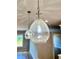 Close up on clear pendant lights overhanging kitchen island with hardwood floors at 1273 Jersey Social Circle Rd, Covington, GA 30014