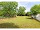 Lush green backyard featuring a wooden deck, mature trees, and a white picket fence, creating a serene outdoor oasis at 3012 Keeneland Blvd, Mcdonough, GA 30252