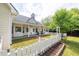 Lush backyard featuring a covered porch, rocking chairs, and a charming white fence at 3012 Keeneland Blvd, Mcdonough, GA 30252