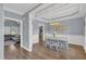 Charming dining room features wainscoting, wood floors, and a stylish chandelier, perfect for Gathering gatherings at 3012 Keeneland Blvd, Mcdonough, GA 30252