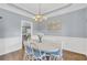 Bright dining room with elegant wainscoting, hardwood floors, and a decorative chandelier at 3012 Keeneland Blvd, Mcdonough, GA 30252