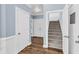 Well-lit hallway with hardwood floors, closet doors, and a staircase leading to the upper level at 3012 Keeneland Blvd, Mcdonough, GA 30252